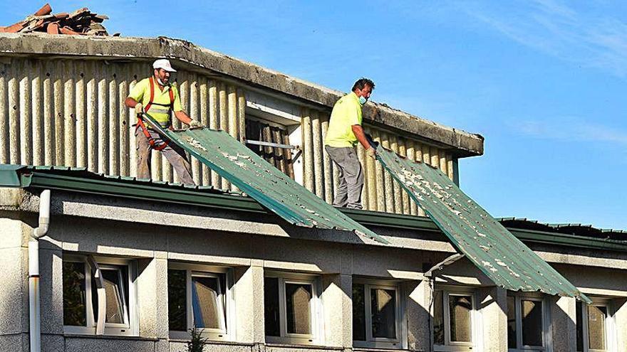 Operarios en el tejado del colegio valgués.