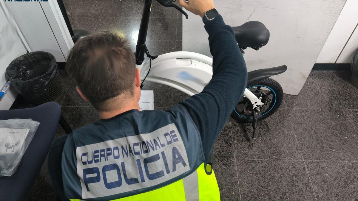Un policía, con uno de los patinetes recuperados.