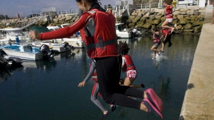 Varios niños se dan un chapuzón en el puerto.