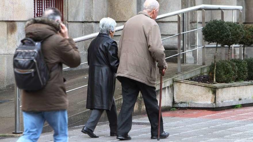 Personas mayores caminan por la calle.