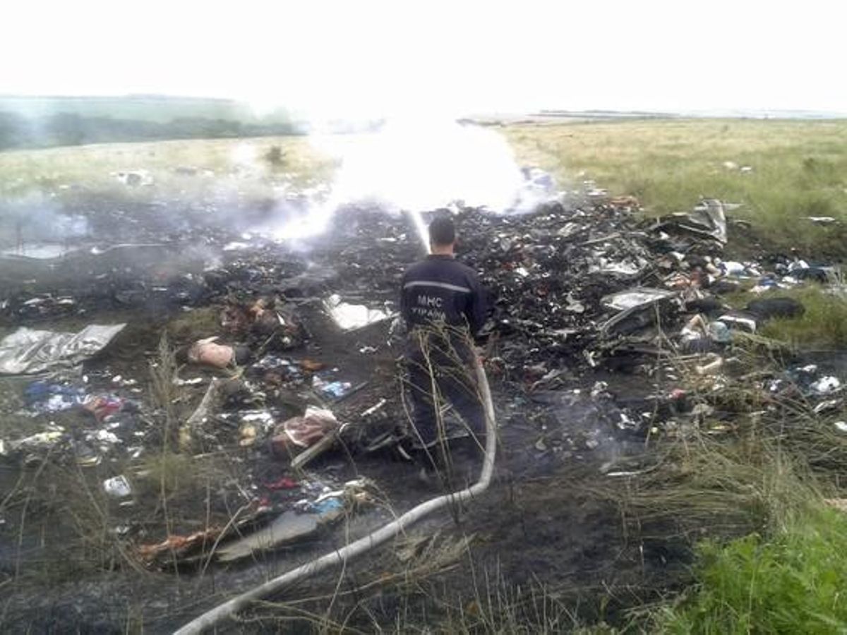 Un operari treballa al lloc on s’ha estavellat l’avió abatut, a la regió ucraïnesa de Donetsk.