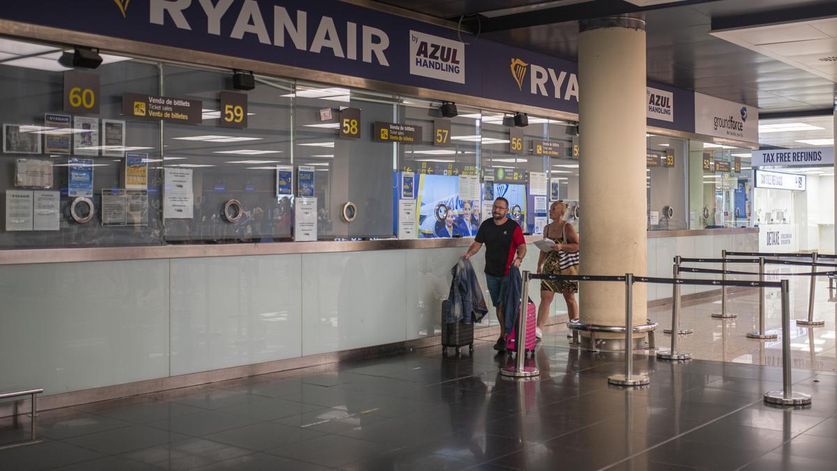 Dos personas pasan junto a una ventanilla de Ryanair