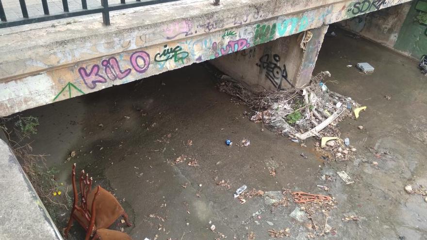 Carritos de compra, sillas desvencijadas y vallas de obra, en el torrente.