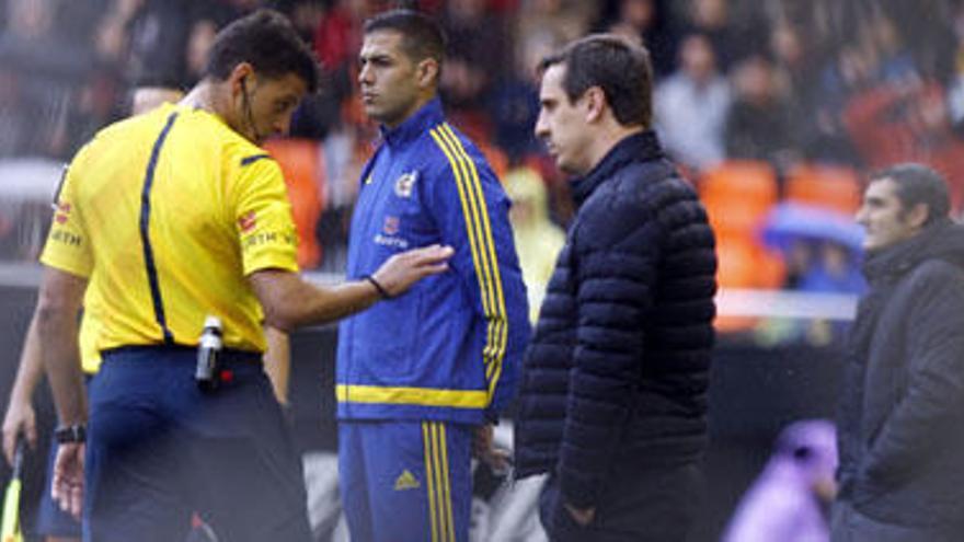 Gil Manzano se dirige a Gary Neville tras la protesta del técnico del Valencia CF.