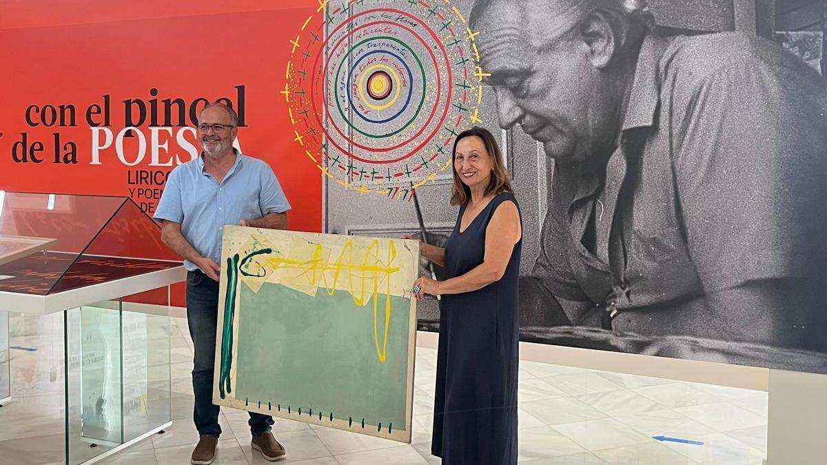 María Dolores Mulá, con el director de la Fundación Rafael Alberti, Uberto Stabile, y una de las obras donadas sobre un poema del gaditano