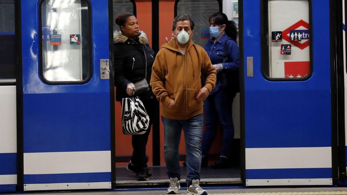 Varias personas con mascarilla en el metro de Madrid.