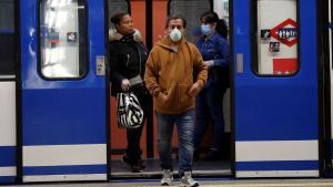 Varias personas con mascarilla en el metro de Madrid.