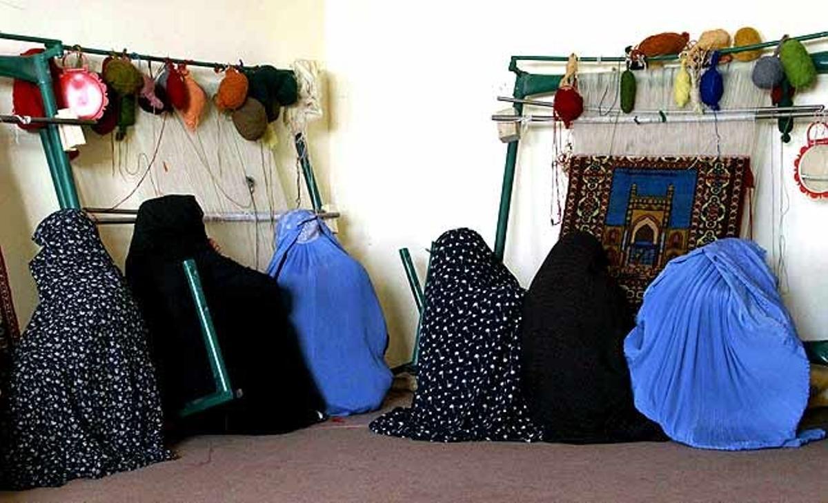 Dones afganeses treballen en la fabricació d’alfombres en un institut de formació professional a Herat (Afganistan). El projecte, finançat per Itàlia, ajuda a retornats i deportats a reintegrar-se socialment a través de la formació.