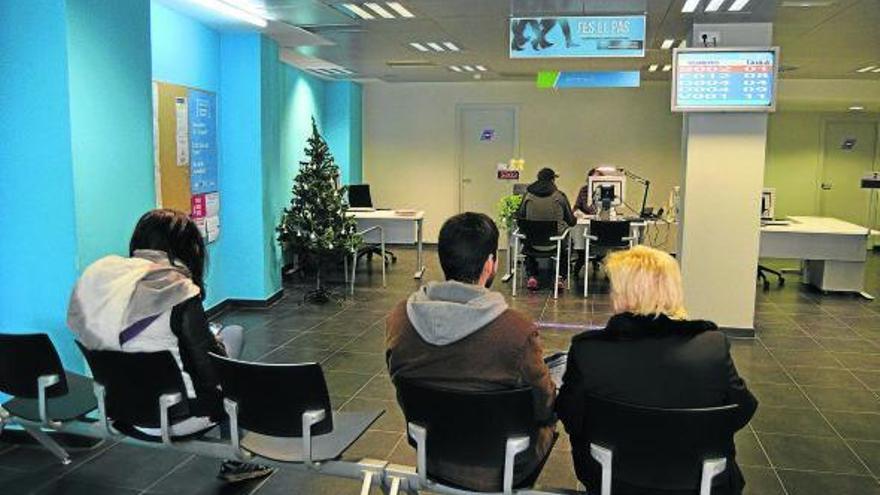 Un grup de persones fa cua en una Oficina de Treball de la Generalitat