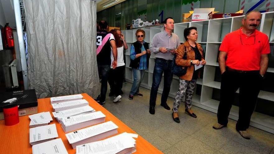 Papeletas y gente a la cola para votar en un colegio vilagarciano, en las anteriores municipales. // I. Abella