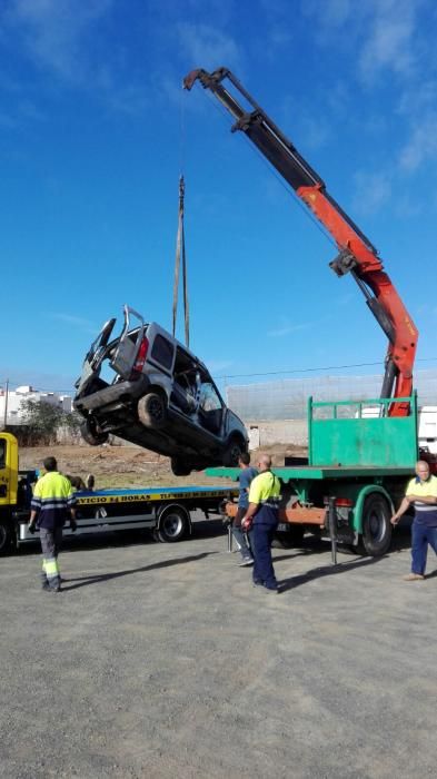 Una brazo articulado iza el vehículo accidentado.