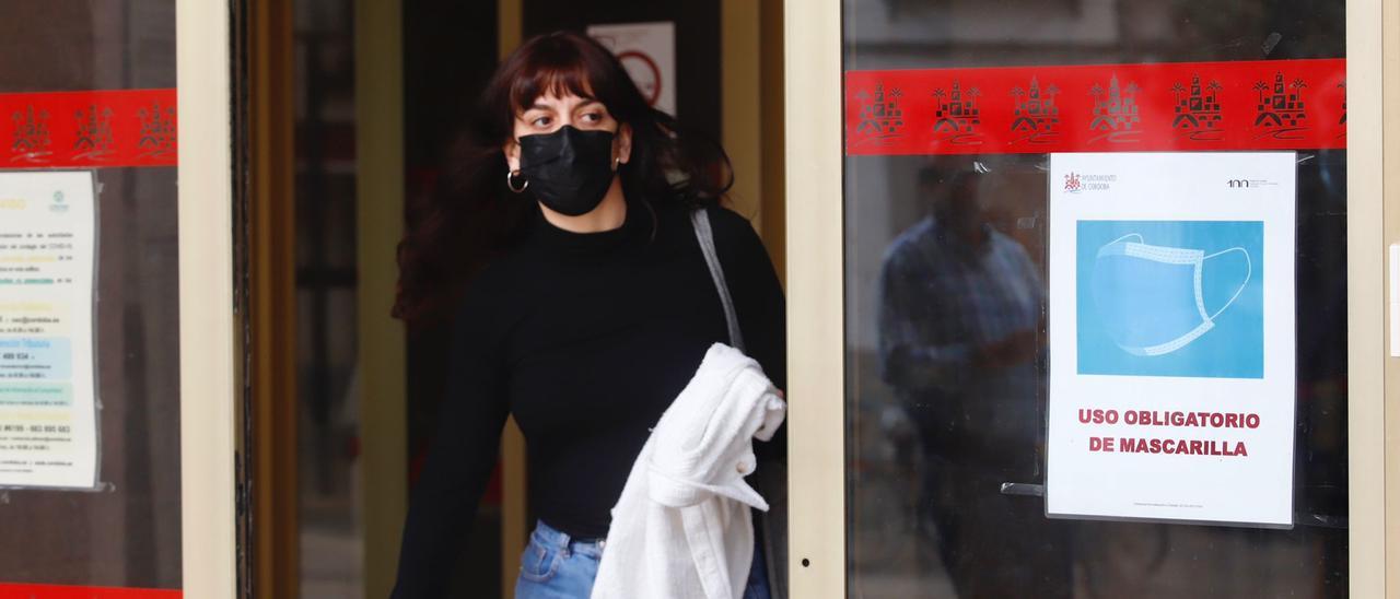 Una mujer sale del Ayuntamiento de Córdoba con la mascarilla puesta.