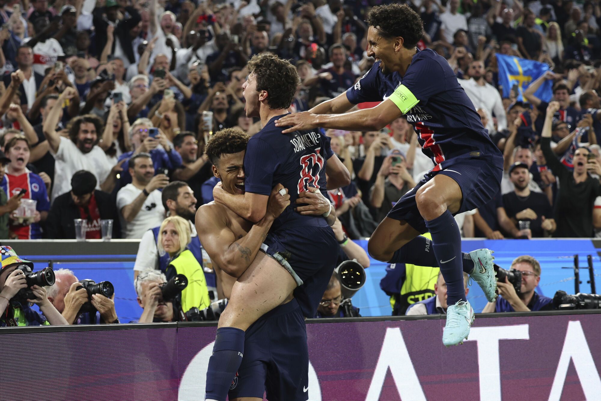 PSG's Desire Doue, left, celebrates after he scored thrid goal during the Champions League final soccer match between Paris Saint-Germain and Inter Milan at the Allianz Arena in Munich, Germany, Saturday, May 31, 2025. (AP Photo/Alexandra Beier)