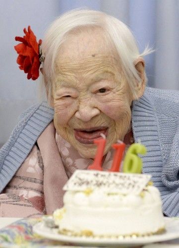 Japanese Misao Okawa, the world's oldest woman, poses for a photo next to her birthday cake as she celebrates her 116th birthday in Osaka