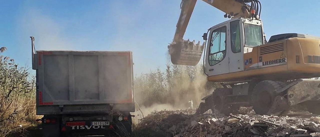 Un  momento en el que la máquina retroexcavadora trabaja junto al camión.  | LEVANTE-EMV