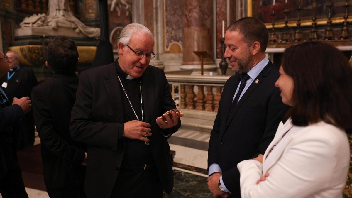 Paloma Saborido, junto al hermano mayor de la Esperanza, Sergio Morales, y el arzobispo de Sevilla, José Ángel Saiz, que bendice un broche que el Cachorro le ha regalado a la Virgen.