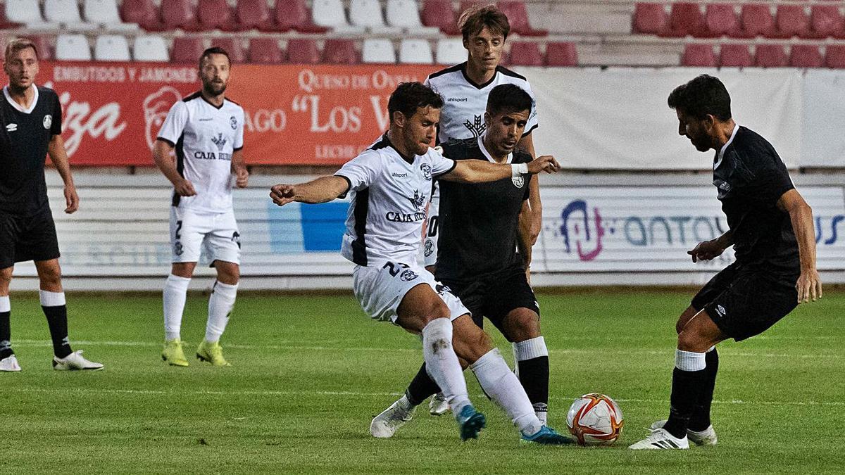 Losada, autor del primer gol rojiblanco ayer, pelea por hacerse con el cuero con dos adversarios. | J. L. Fernández