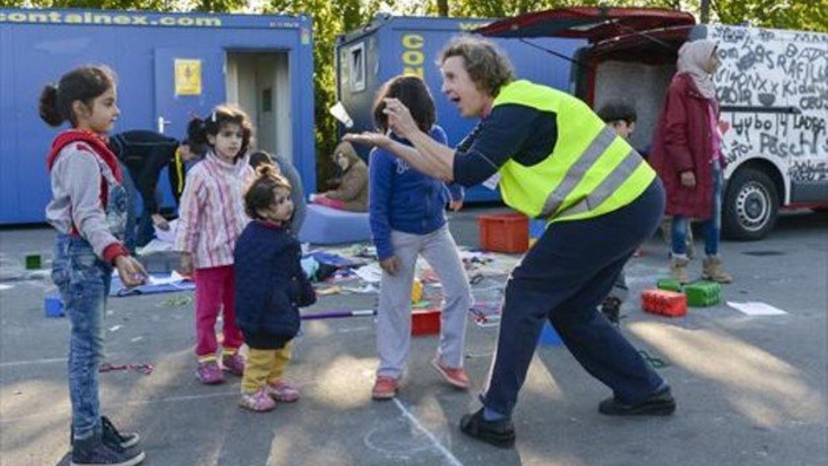 Una voluntaria juega con unos niños  en un campo de refugiados en la ciudad de Salzburgo.