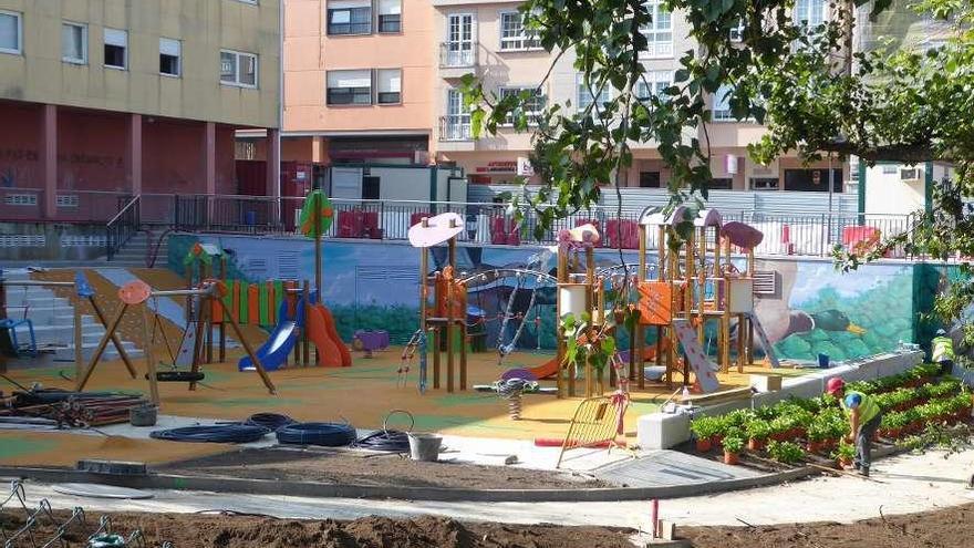 Obreros con macetas junto al parque infantil y al fondo el mural. A la derecha, soterrado, el tanque de tormentas.