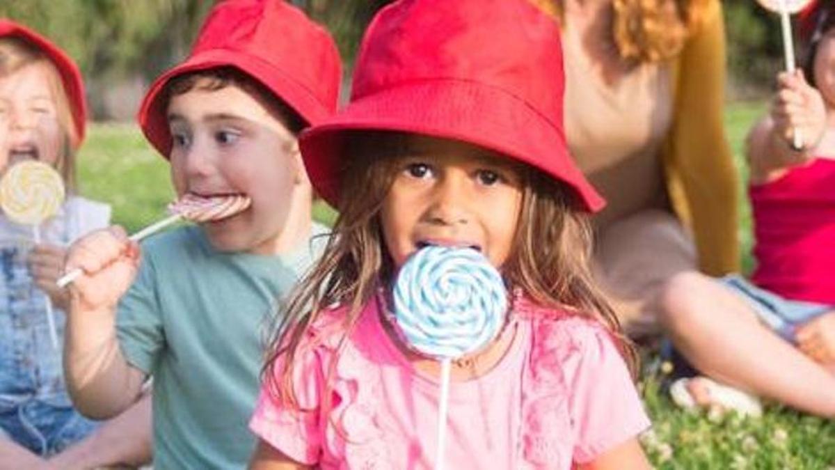 Varios niños comiendo piruletas.