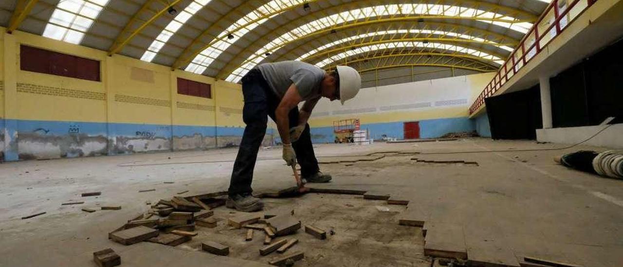 Uno de los operarios trabaja en el interior del polideportivo.