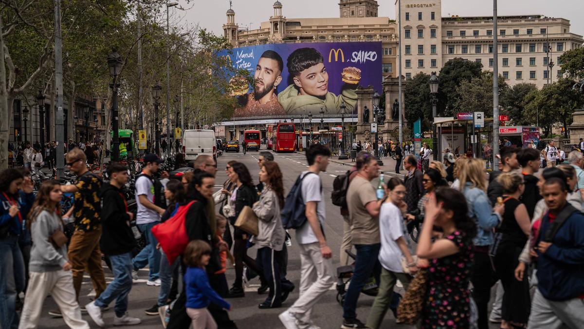 Gente paseando junto a la plaza de Catalunya.