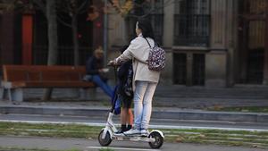 Una mujer lleva a un menor en un patinete eléctrico, a mediados de noviembre, en Barcelona.