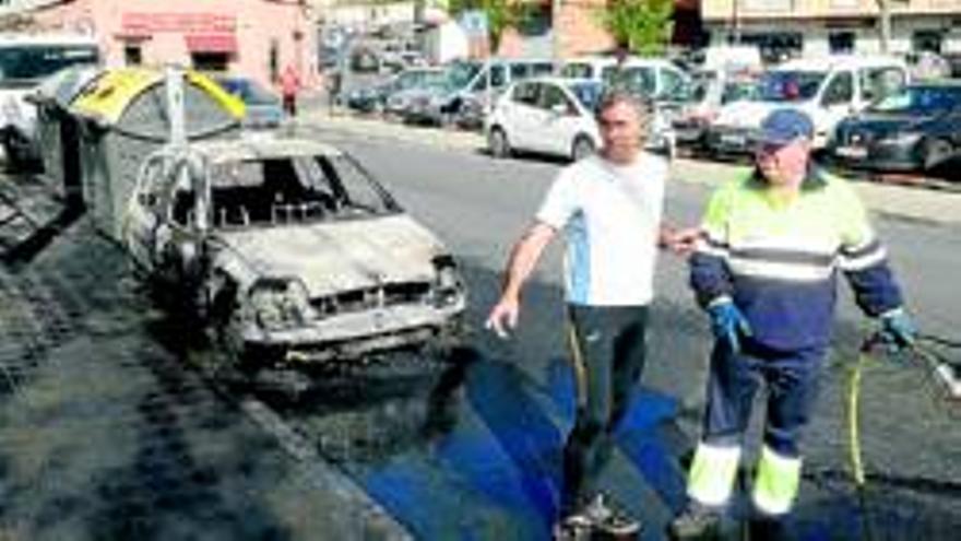 Un coche quemado al arder contenedores