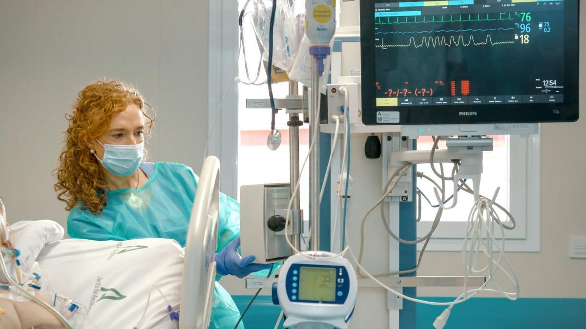 Una sanitaria proporciona cuidados de enfermería a un paciente ingresado en el centro hospitalario.