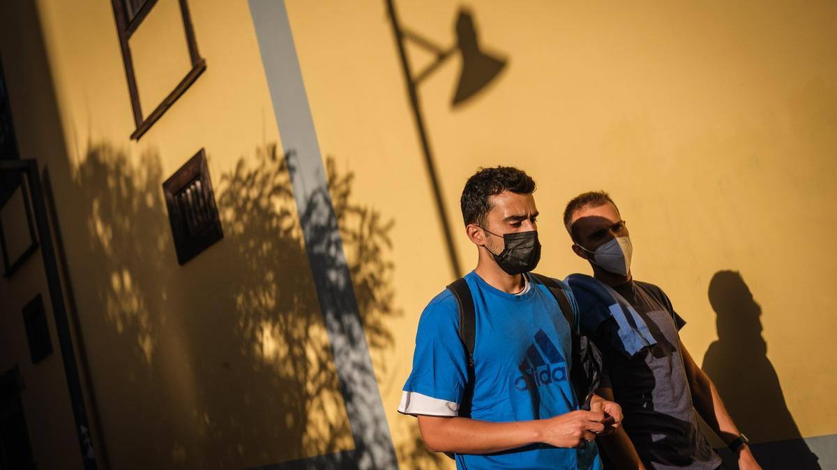 Dos hombres con mascarillas pasean por La Laguna.