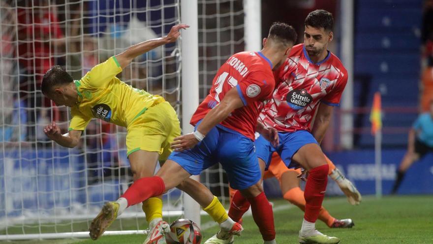 Yeremay Hernández intenta escaparse de dos futbolistas del Lugo en el partido de ida. |  // LOF