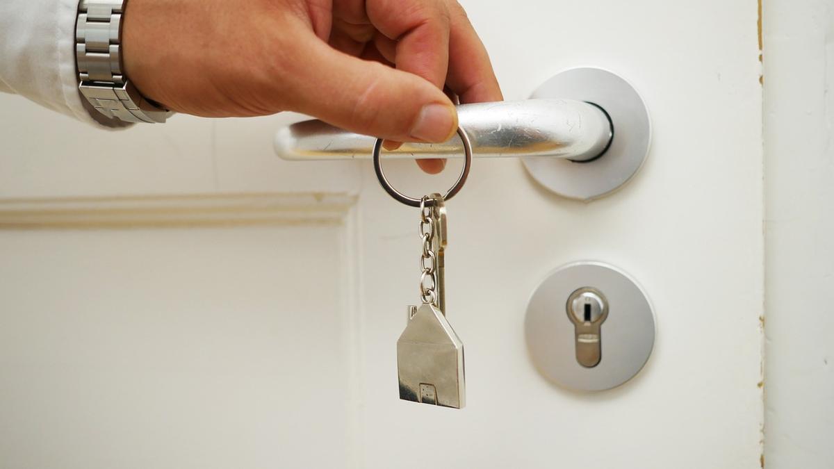 Una persona intenta abrir la puerta de casa con las llaves