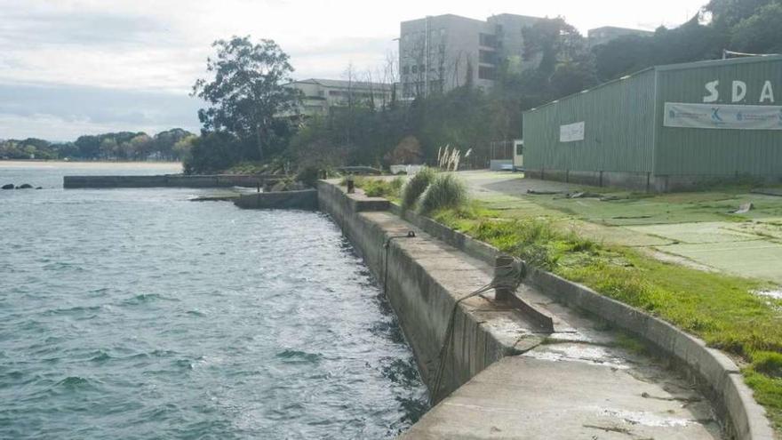 Muelle del antiguo astillero Valiña, junto a la playa de Oza, con Santa Cristina al fondo.