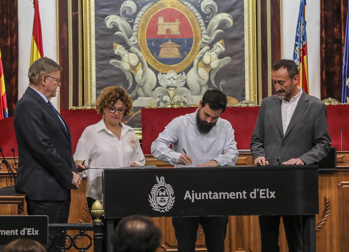 Raúl Verdú firma en presencia de Ximo Puig, Josefina Bueno y Carlos González.