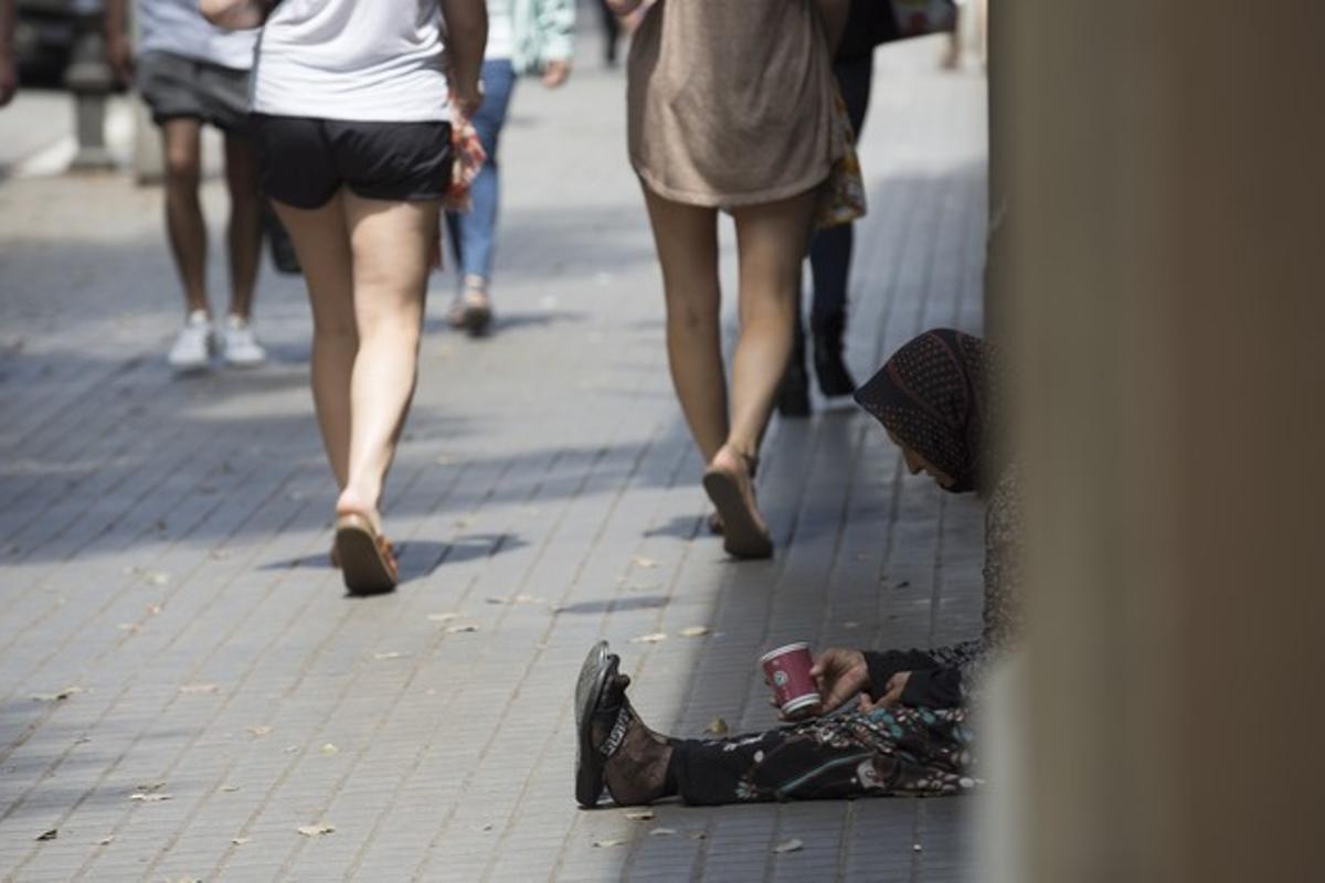 Un indigente pide limosna en una calle de Barcelona.