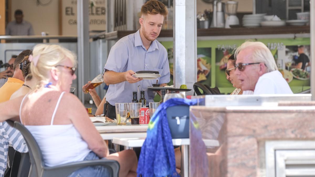 Un camarero atiende a una mesa de turistas en una terraza del Archipiélago.
