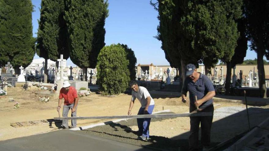 Operarios de Santa Cristina realizando trabajos en el cementerio municipal.