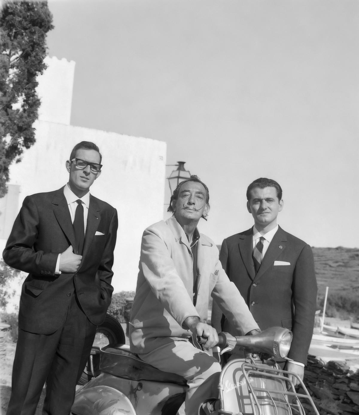 Los jóvenes aventureros Antonio Veciana y Santiago Guillén con Salvador Dalí y la vespa pintada en Portlligat.