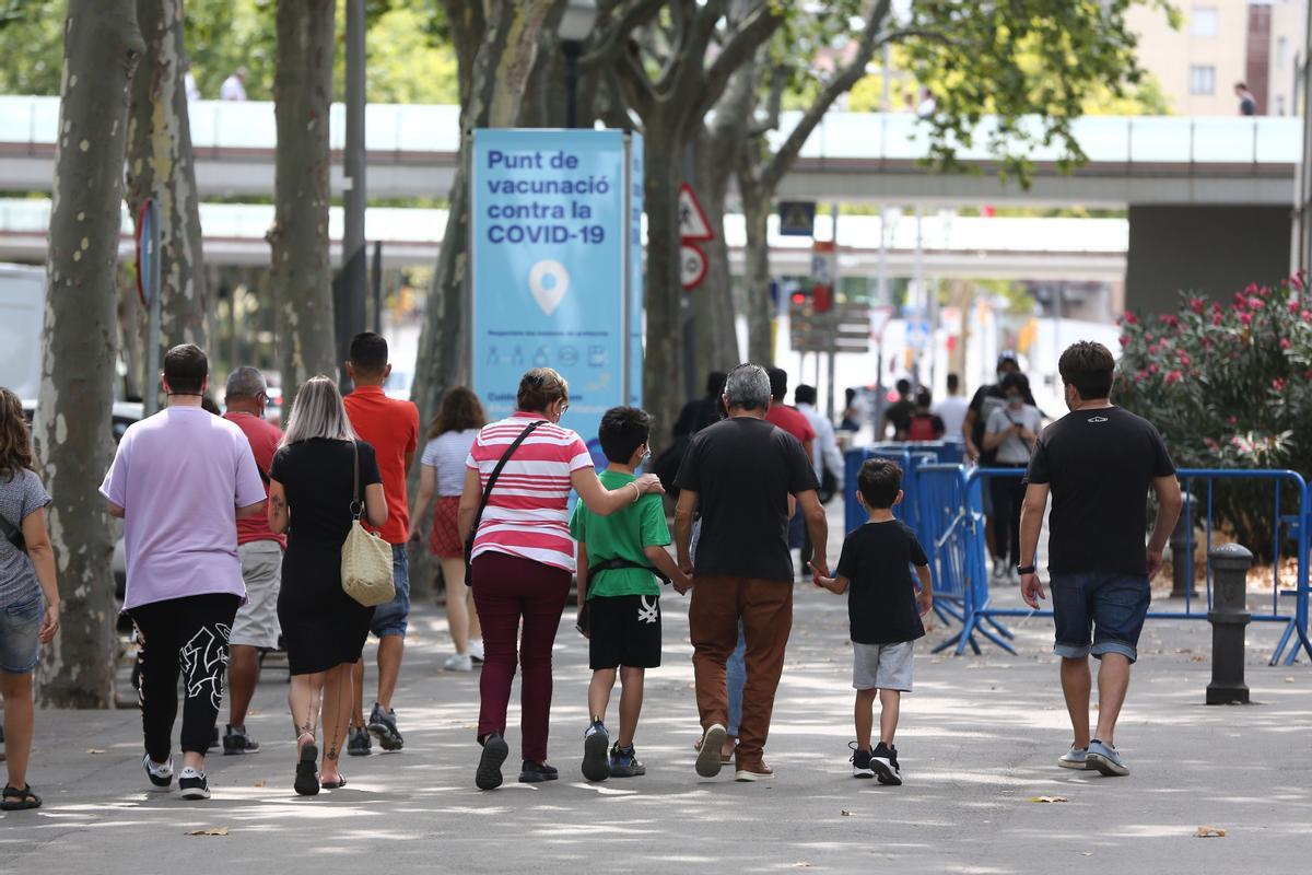 Menores acompañados por sus padres acuden al centro de vacunación de la Fira de Barcelona.