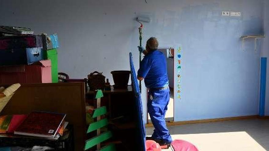 Un operario municipal pinta las paredes de un centro escolar.