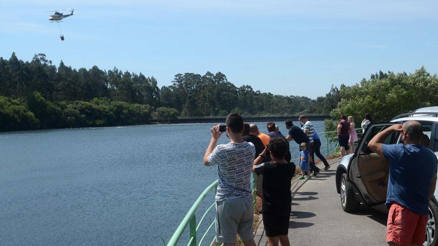 Ciudadanos observando las maniobras de los helicópteros, en el embalse de Castroagudín.