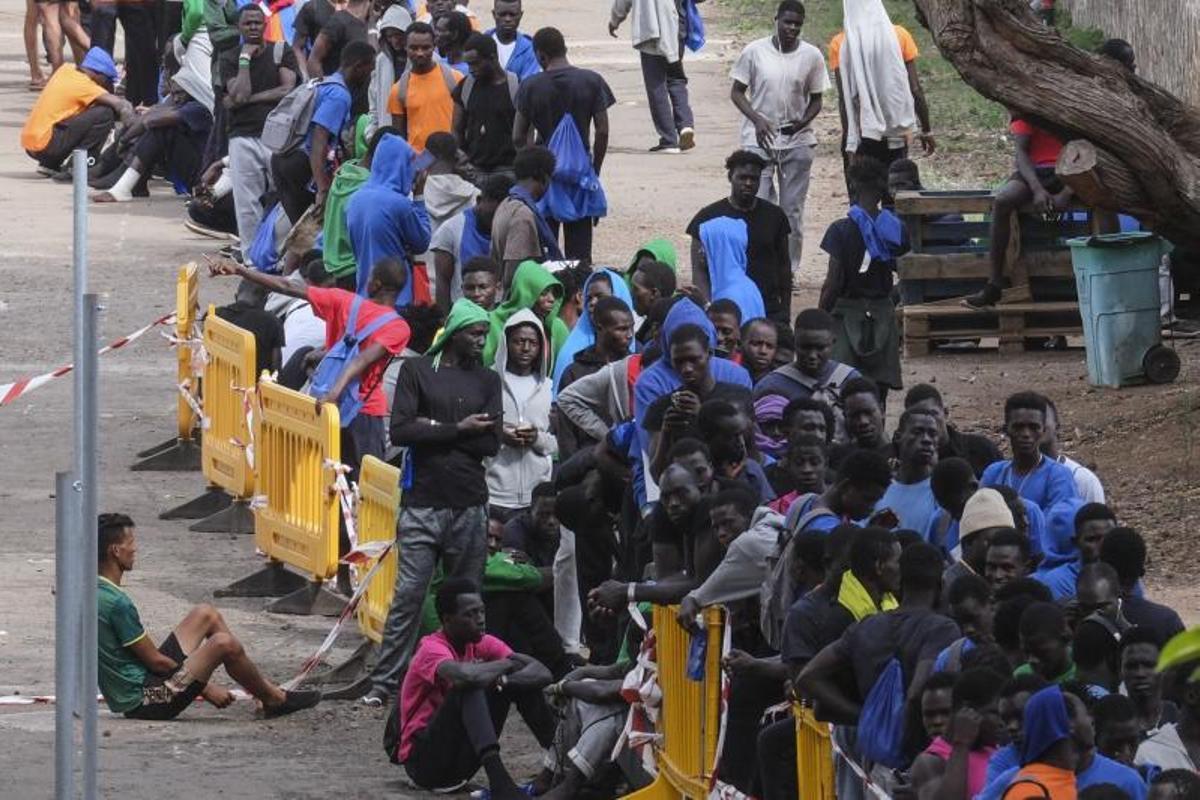 Decenas de inmigrantes hacen cola en el centro de acogida de Las Raíces, en La Laguna (Tenerife).