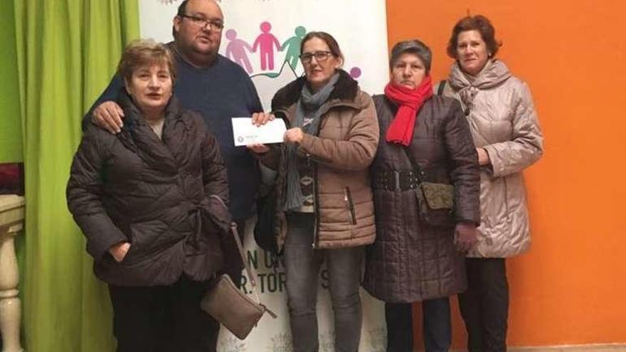 Nati de la Torre (centro) entrega el donativo a la asociación.