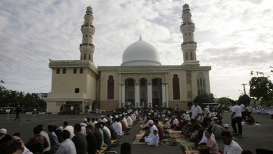 Musulmanes rezan frente a uan mezquita de Indonesia