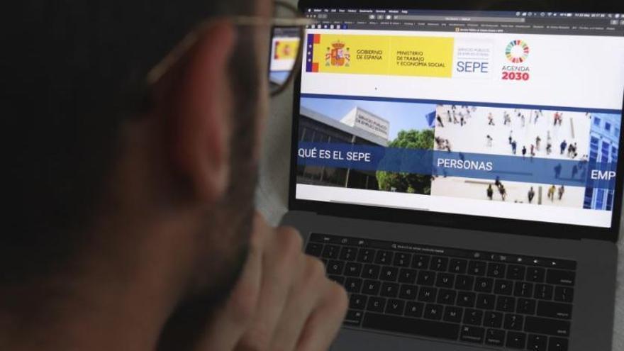 Un home mirant la pàgina web del SEPE