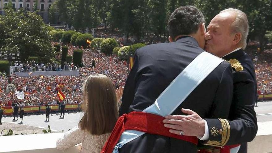 Felipe VI da un beso a don Juan Carlos en el balcón del Palacio Real. Delante, la Princesa Leonor.
