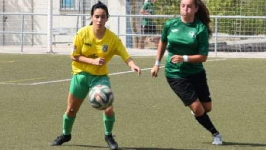 Una jugadora de cada equipo pelea por el balón.