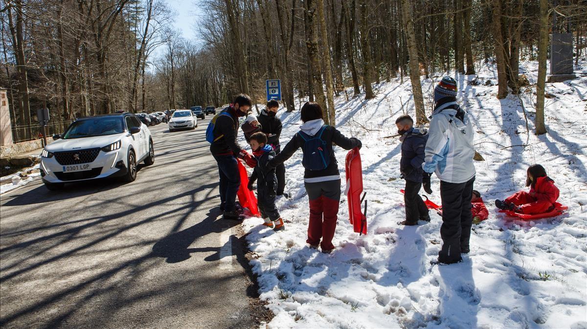 Una familia, perfectamente equipada con cuatro trineos para la que se supone que será la última nieve de la temporada en el Montseny.