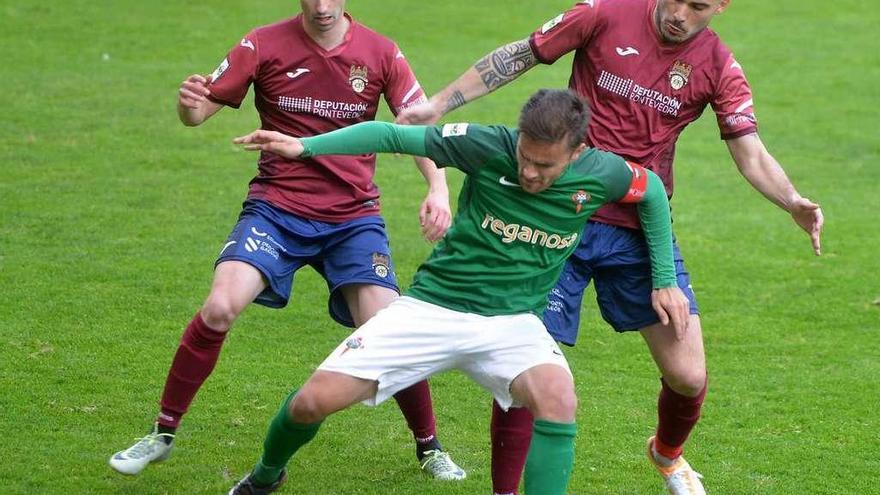 El jugador del Racing de Ferrol Pablo Rey protege el balón ante la presión de Nacho López y Álex Fernández. // Gustavo Santos