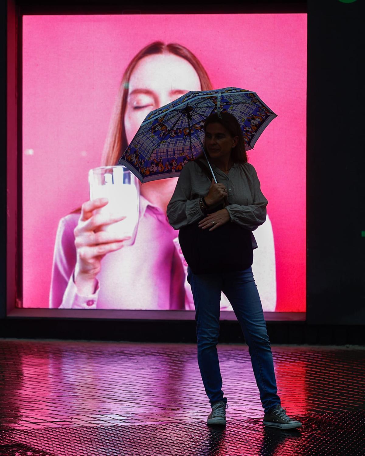 Una persona espera bajo la lluvia en València
